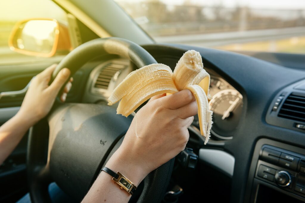 Person eating a banana while driving